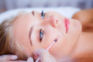 Woman receiving a botox injection in her lips